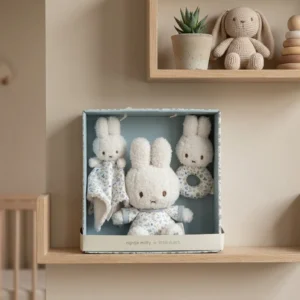 Nijntje Miffy cadeauset met drie witte knuffelkonijnen in bloemenjurkjes in geschenkdoos op houten plank
