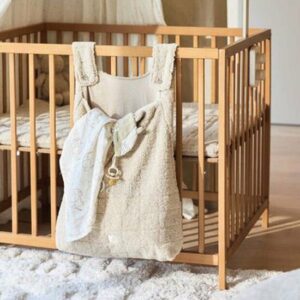 Beige teddy stoffen opbergtas hangend aan houten babybox met sleutelhanger detail
